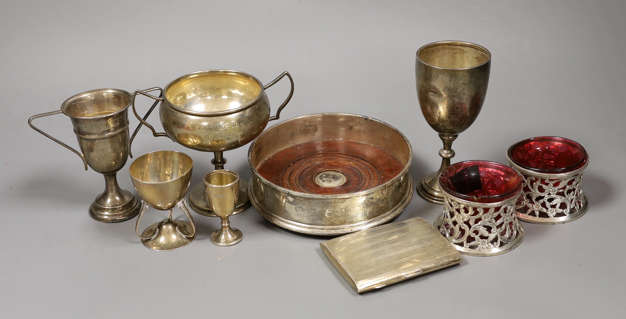 Sundry small silver including a modern wine coaster, a pair of Irish pierced silver salts(a.f.), two goblets, two small trophy cups and a cigarette case.